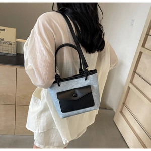 Détail du sac seau bleu clair avec pochette en cuir noir et bandoulière réglable
