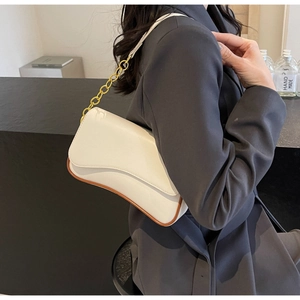 Detailansicht der weißen Achseltasche mit Goldkette und braunem Lederbesatz-Akzenten