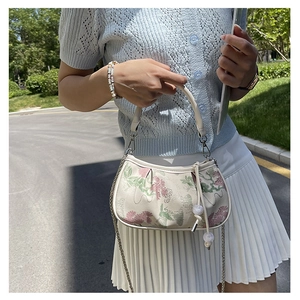 Detail of floral embroidery on off-white crossbody bag with pearl drawstring and chain