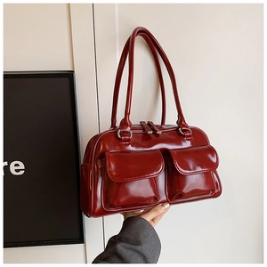 Close-up of glossy burgundy tote bag with dual front pockets and double straps