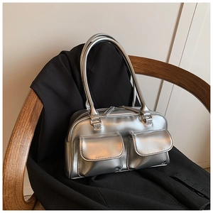 Detail of silver metallic bowling bag with front flap pockets on a wooden chair