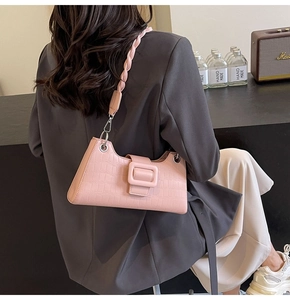 Detailed shot of pink crocodile pattern baguette bag with stylish woven shoulder strap