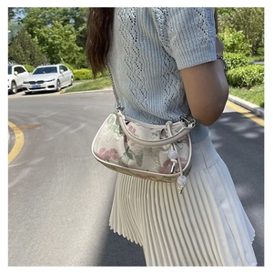 Detailed shot of floral embroidered square bag with metal chain and pearl drawstring
