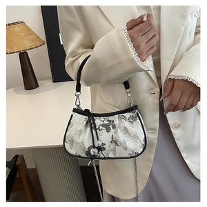 Detail of Chinese style embroidery on a white small crossbody bag with floral pattern