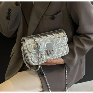 Close-up of silver quilted crossbody bag with metallic finish and metal chain strap