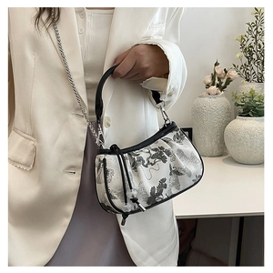 Detail of white square handbag with black ink embroidery and silver metal chain strap