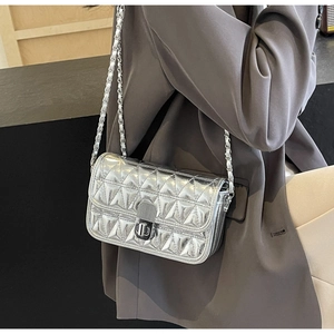Detail of silver quilted crossbody bag with diamond pattern and metal chain strap