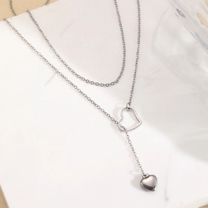 Elegant double layer silver necklace featuring open and solid heart shaped pendants