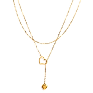 Detail view of double-layer gold necklace featuring open heart and solid heart pendants