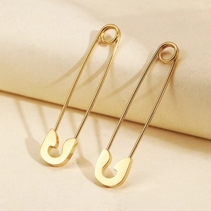Boucles d'oreilles épingle de sûreté dorées au design industriel minimaliste chic