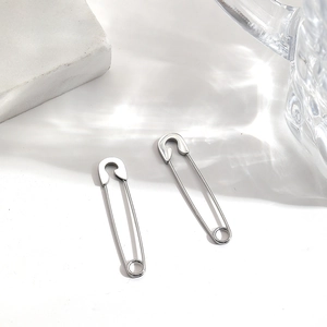 Vue macro des boucles d'oreilles épingle de sûreté en acier poli sur surface minérale