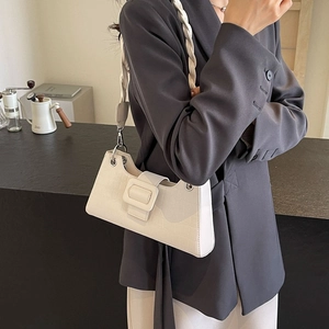 Chic white croc-embossed baguette bag with top handle, worn by a model in a gray suit