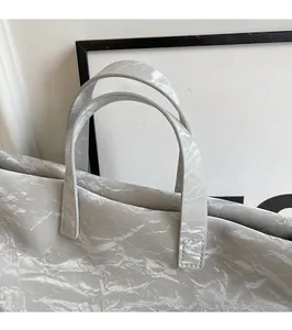 Detail of sturdy PU leather double handles on a grey textured tote handbag