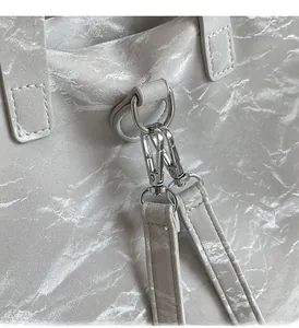 Macro detail of silver metal hardware hooks on marble textured silver gray tote bag