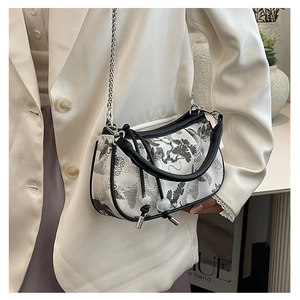 Detailed shot of ink landscape embroidery on the handbag with bead drawstring and chain