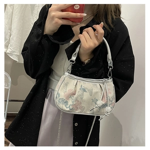Detail of embroidered floral crane pattern and silver leather trim on women's bag