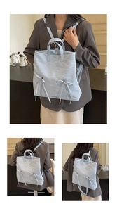 Detail view of light blue preppy backpack showing wrinkled leather texture and zip straps
