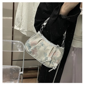Detail of embroidered floral handbag with silver metal chain and pearl bead drawstring