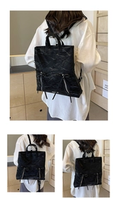 Detail of black pleated faux leather backpack with decorative bows and metal zippers