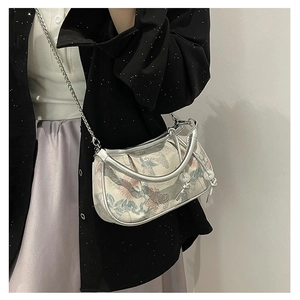 Detailed embroidery on vintage-style jacquard bag with metallic trim and pearl tassel