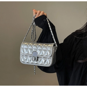 Detail of silver quilted texture fabric and metal twist lock on the crossbody bag