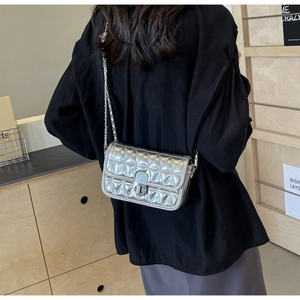 Detailed view of silver quilted metallic handbag with chain strap and twist lock clasp