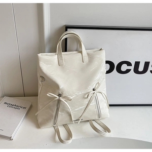 Detail of cream white backpack featuring marble texture, bow zippers and sturdy handles
