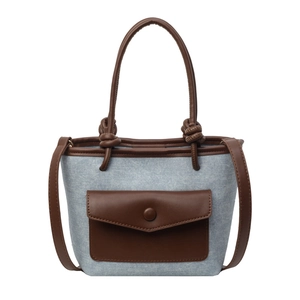 Sac seau femme en denim bleu et cuir marron avec une poignée nouée au style moderne