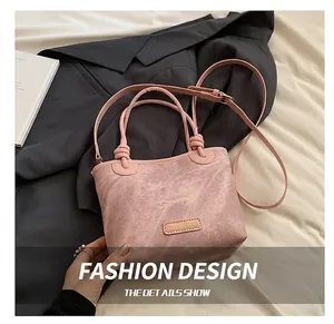 Detail of dusty pink bucket bag showing washed texture and knot handle design