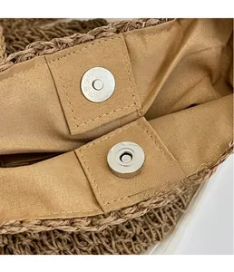 Gros plan du fermoir magnétique en métal et de la texture tressée du sac seau en paille