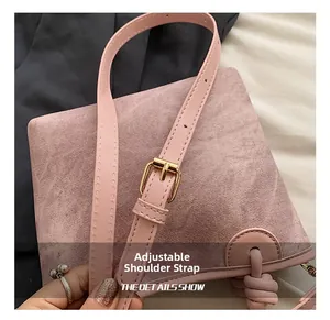Close-up of adjustable pink shoulder strap with gold buckle on textured bucket bag