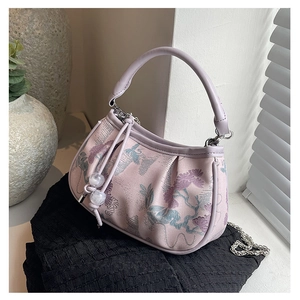 Detail of lavender satin bag with floral embroidery, pearl accents and round handle