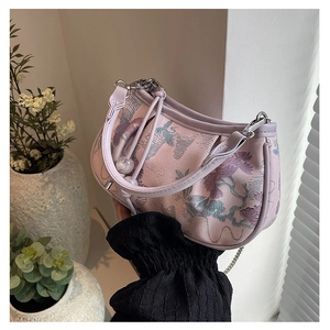 Close-up of pink hobo bag featuring floral embroidery, silver chain, and bead details