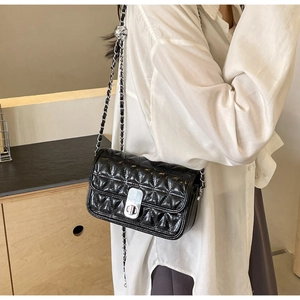 Close-up of black quilted chain bag featuring glossy finish and silver metal twist-lock