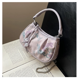Detail of floral embroidery and metallic chain on a small pink New Chinese style handbag