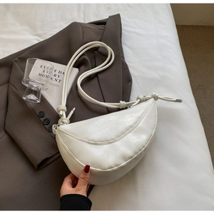 Detail of white half-moon shoulder bag with textured leather and knotted rope strap