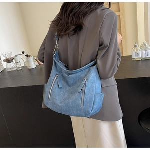 Detail of vintage blue multi-pocket biker tote bag shown on model for daily commute