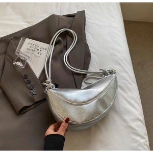 Detail of silver crescent shoulder bag featuring metallic cracked leather texture