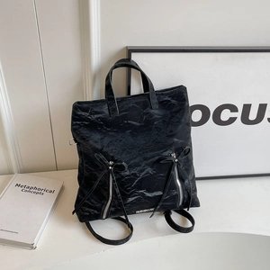 Black crinkled nylon backpack with ribbon bow and silver zippers for commuting