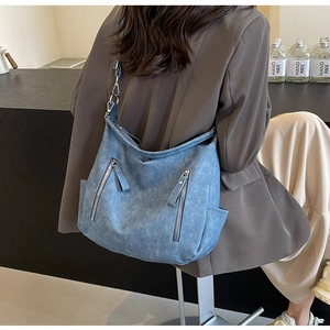 Detail of vintage blue canvas tote bag showing zipper pockets and adjustable strap