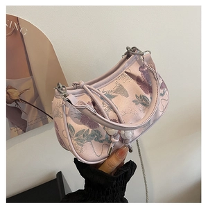 Detail of pink floral jacquard embroidery on hobo bag with a zipper and metal chain