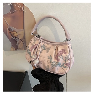 Detail of pink embroidered square bag with floral jacquard and beaded drawstring