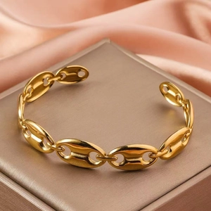 Bracelet jonc grain de café doré poli pour femme sur fond en soie élégant