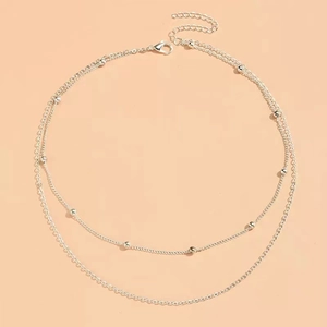 Double-layered silver snake chain necklace with small beads and lobster clasp closure