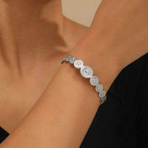 Vintage silver stainless steel cuff bracelet with sunburst textured round discs on wrist