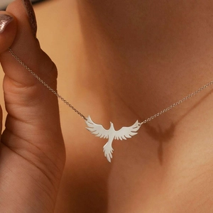 Collier avec pendentif phénix en acier inoxydable argenté porté au cou d'une femme