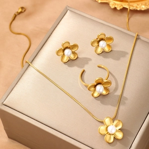 Detail of 18k gold floral jewelry set with matte finish and white pearl center