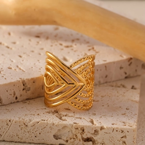 Minimalist geometric hollow layered stainless steel ring in gold on travertine stone background