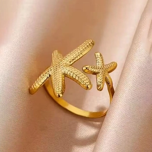 Golden stainless steel starfish open ring featuring detailed textures on a satin backdrop