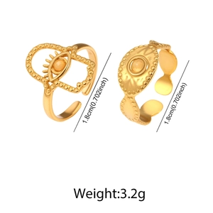 Detailed view of two gold stainless steel rings with evil eye and hammered textures